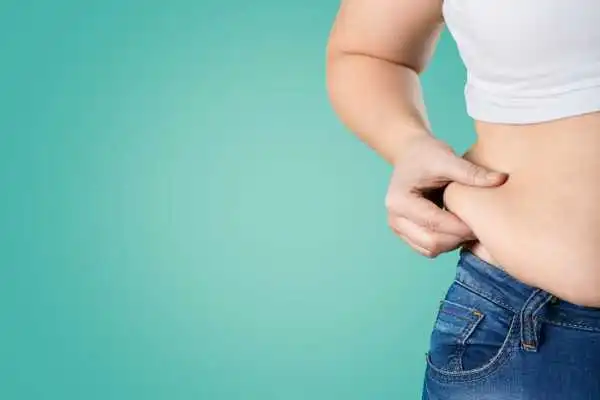 Image of woman pinching her love handles to show weight gain Braintree